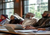 A diverse group of religious leaders in traditional attire sitting in a modern seminar room, engaged in a discussion with laptops and notebooks on the table, natural lighting from large windows, reali