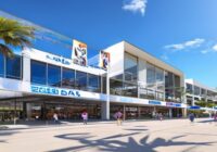 Photorealistic wide shot of the Palau Municipal d'Esports in Badalona, Spain, exterior view with modern architecture, clear blue sky, banners of ACB Supercopa hanging from the facade, people entering