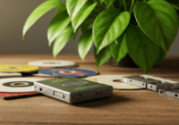 A close-up of a vintage portable MP3 player on a wooden table, surrounded by old CDs and cassette tapes, with a green plant in the background, symbolizing the eco-friendly shift from physical to digit