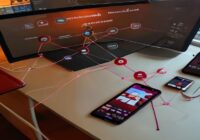 A high-angle view of a modern desk with a monitor displaying an n8n workflow: nodes labelled 'Image Input', 'GPT-4 Vision', 'HTML Template', and 'Shopify API' connected in a flow. On the side, a smart